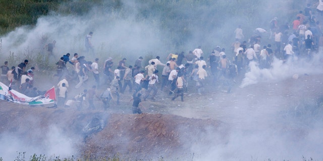 June 5: Pro-Palestinian protesters run from tear gas fired by Israeli troops along the border between Israel and Syria near the village of Majdal Shams in the Golan Heights.
