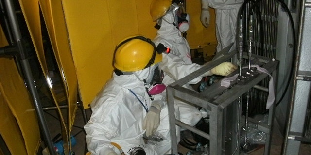June 3: Workers try to install a pressure indicator inside the Unit 1 reactor at Fukushima Dai-ichi nuclear power plant in Okuma, Fukushima Prefecture, northern Japan.