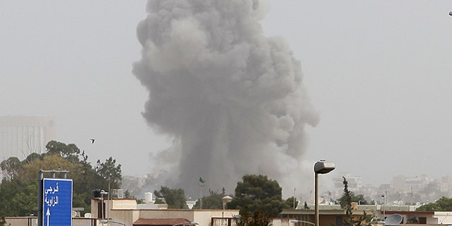 June 7: A smoke and dust cloud from an explosion rises into the sky after a NATO airstrike in Tripoli, Libya.
