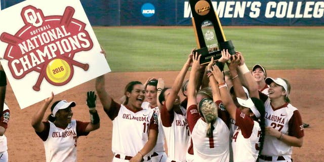 Oklahoma players celebrate with the trophy after defeating Auburn 2-1 in the deciding game of the championship series of the NCAA softball College World Series, Wednesday, June 8, 2016, in Oklahoma City. (AP Photo/Sue Ogrocki)