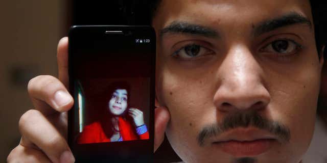 June 8, 2016: Hassan Khan shows the picture of his wife Zeenat Rafiq, who was burned alive, allegedly by her mother, on a mobile phone at his home in Lahore, Pakistan.