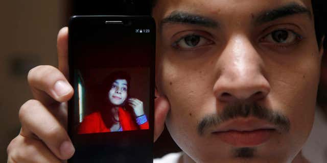 June 8, 2016: Hassan Khan shows the picture of his wife Zeenat Rafiq, who was burned alive, allegedly by her mother, on a mobile phone at his home in Lahore, Pakistan.