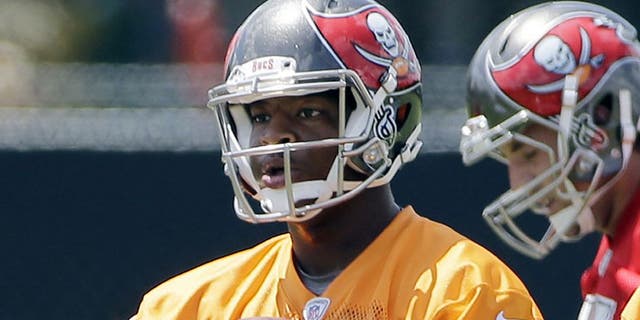 Tampa Bay Buccaneers quarterback Jameis Winston carries a handful of footballs during an NFL football organized team activity, Thursday, June 4, 2015, in Tampa, Fla. (AP Photo/Chris O'Meara)