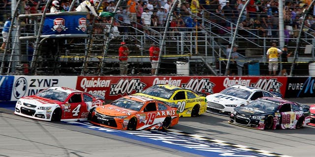 BROOKLYN, MI - JUNE 14: Carl Edwards, driver of the #19 ARRIS Toyota, and Kevin Harvick, driver of the #4 Budweiser/Jimmy John's Chevrolet, lead the field to a restart during the NASCAR Sprint Cup Series Quicken Loans 400 at Michigan International Speedway on June 14, 2015 in Brooklyn, Michigan. (Photo by Jerry Markland/Getty Images)
