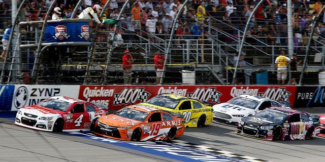 BROOKLYN, MI - JUNE 14: Carl Edwards, driver of the #19 ARRIS Toyota, and Kevin Harvick, driver of the #4 Budweiser/Jimmy John's Chevrolet, lead the field to a restart during the NASCAR Sprint Cup Series Quicken Loans 400 at Michigan International Speedway on June 14, 2015 in Brooklyn, Michigan. (Photo by Jerry Markland/Getty Images)