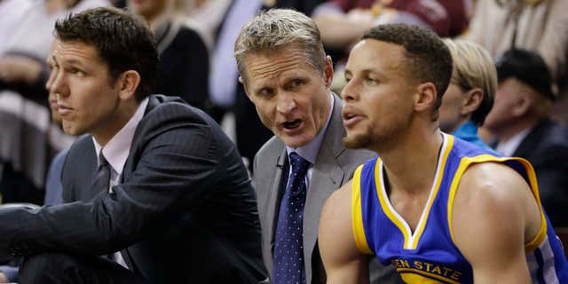 June 8, 2016: Golden State Warriors coach Steve Kerr, center, talks with guard Stephen Curry on the bench during the first half against the Cleveland Cavaliers in Game 3 of basketball's NBA Finals in Cleveland.