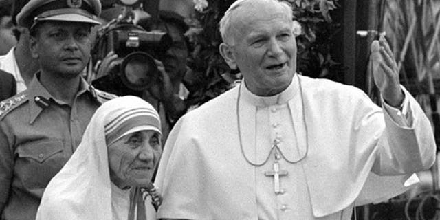 Pope John Paul II holds hands with Mother Teresa after visiting the Casa del Cuore Puro, Mother Teresa's home for the destitute and dying in the eastern Indian city of Calcutta, in this Feb. 3, 1986 file photo.