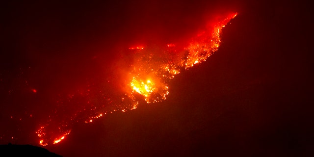 June 8: A mountain top glows from the Horseshoe Two fire near Paradise and Portal, Ariz.