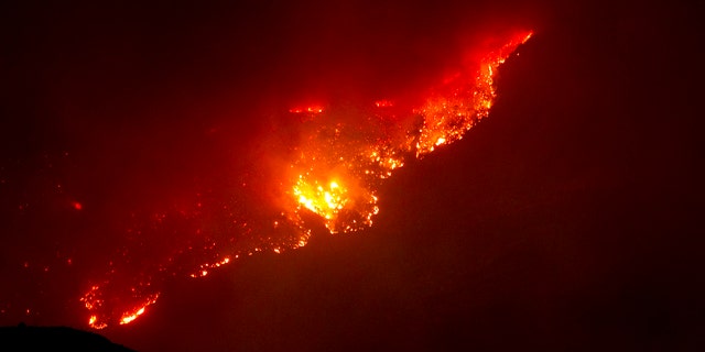 June 8: A mountain top glows from the Horseshoe Two fire near Paradise and Portal, Ariz.