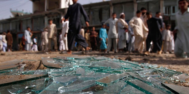 June 11: Afghans walk pass the derbis at the site of a bomb explosion in Laghman province east of Kabul, Afghanistan.