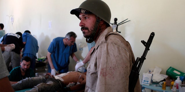 June 10: A Libyan rebel fighter arrives at a hospital as others receive treatment in Misrata, Libya.