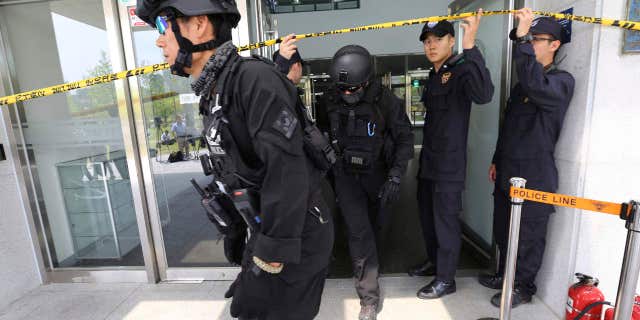 South Korean police officers come out of an engineering faculty building at Yonsei University in Seoul, South Korea, Tuesday, June 13, 2017.