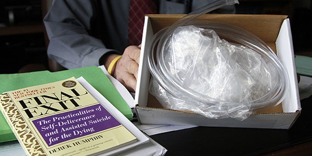 In this May, 12, 2011 file photo, Oregon State Sen. Floyd Prozanski shows a "suicide kit" consisting of the book "Final Exit," plastic tubing and a plastic bag with a collar that fits over a person's head at his Capitol office in Salem, Ore.