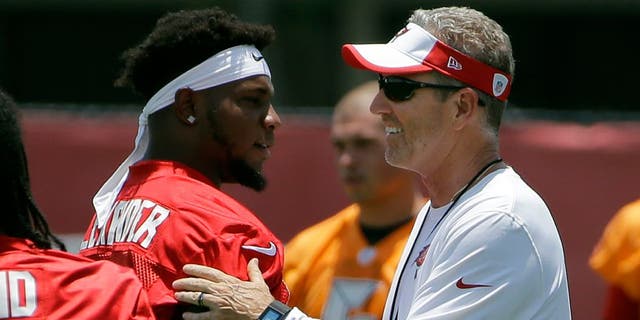Tampa Bay Buccaneers head coach Dirk Koetter, right, greets middle linebacker Kwon Alexander (58) before drills at an NFL football minicamp Tuesday, June 14, 2016, in Tampa, Fla. (AP Photo/Chris O'Meara)