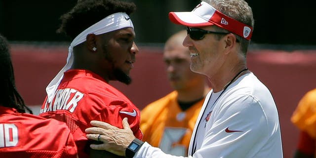 Tampa Bay Buccaneers head coach Dirk Koetter, right, greets middle linebacker Kwon Alexander (58) before drills at an NFL football minicamp Tuesday, June 14, 2016, in Tampa, Fla. (AP Photo/Chris O'Meara)