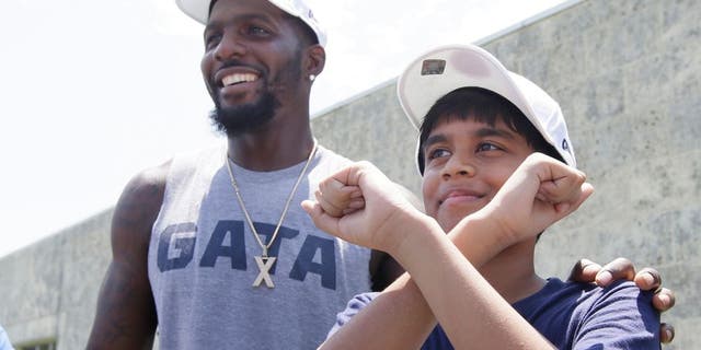 Dallas Cowboys wide receiver Dez Bryant, left, stands by as 11-year-old spelling bee champion Nahir Janga of Austin, throws up a celebratory 'X' at the NFL football team's minicamp at Valley Ranch in Irving, Texas, Wednesday, June 15, 2016. Janga was on hand to visit with the Cowboys and meet Bryant who inspired him to throw up an 'X' when he won the spelling bee. (AP Photo/LM Otero)