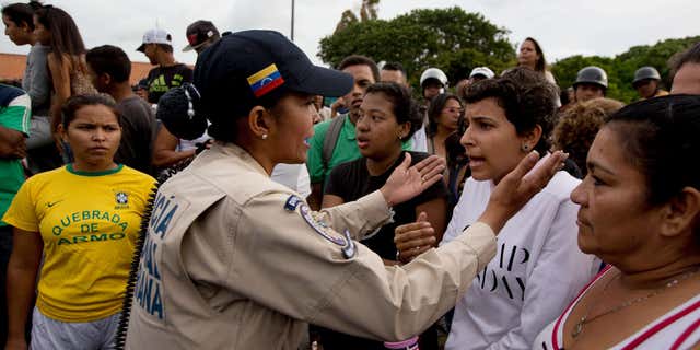 June 14, 2016: A police officer talks to an angry crowd during a protest for food at the Catia neighborhood in Caracas, Venezuela.
