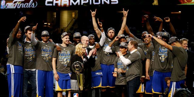 CLEVELAND, OH - JUNE 16: The Golden State Warriors celebrates with the Larry O'Brien NBA Championship Trophy after winning Game Six of the 2015 NBA Finals against the Cleveland Cavaliers at Quicken Loans Arena on June 16, 2015 in Cleveland, Ohio. NOTE TO USER: User expressly acknowledges and agrees that, by downloading and or using this photograph, user is consenting to the terms and conditions of Getty Images License Agreement. (Photo by Ezra Shaw/Getty Images)