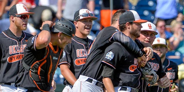 Oklahoma State starting pitcher Thomas Hatch, third from right, is congratulated by teammates after the last out of an NCAA men's College World Series baseball game against UC Santa Barbara in Omaha, Neb., Saturday, June 18, 2016. (AP Photo/Mike Theiler)