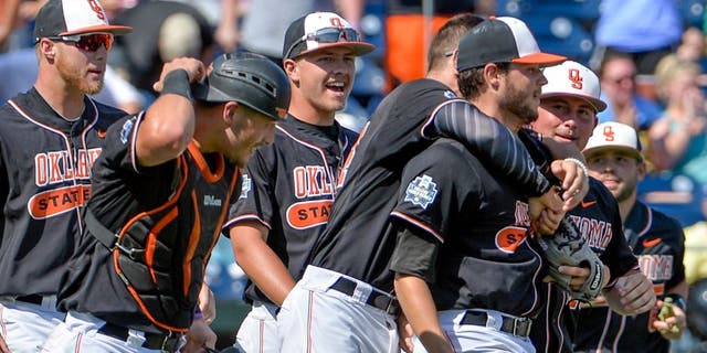 Oklahoma State starting pitcher Thomas Hatch, third from right, is congratulated by teammates after the last out of an NCAA men's College World Series baseball game against UC Santa Barbara in Omaha, Neb., Saturday, June 18, 2016. (AP Photo/Mike Theiler)