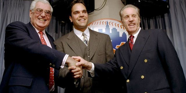 26 Oct 1998: Mike Piazza of the New York Mets shakes hands with Mets Owners Fred Wilpon (R) and Nelson Doubleday (L) during a Press Conference in New York City, New York. Mandatory Credit: Jamie Squire /Allsport