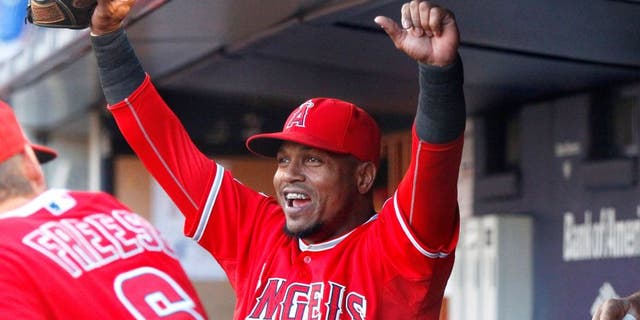 Jun 6, 2015; Bronx, NY, USA; Los Angeles Angels shortstop Erick Aybar (2) reacts in the dugout after watching the Belmont Stakes race on the giant video board prior to the game against the New York Yankees at Yankee Stadium. Mandatory Credit: Andy Marlin-USA TODAY