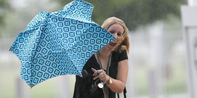 June 17, 2015: Betsy Lauritzen reacts after she was caught off guard by a strong gust of wind caused by Tropical Depression Bill in Arlington, Texas.