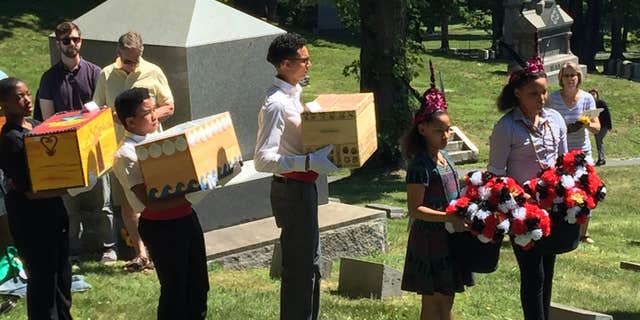 June 18, 2016: In this photo provided by the Albany Diocesan Cemeteries, pallbearers carry the remains of 14 slaves to awaiting graves at St. Agnes Cemetery in Albany, N.Y.