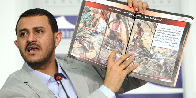 June 18, 2015: Hamza al-Houthim head of the Houthi delegation, shows photographs of injured and killed children as he speaks on human rights during a press conference on the Yemen peace talks at the Geneva Press Club in Geneva, Switzerland.