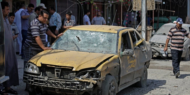June 20: People inspect at the scene a car bomb attack in Baghdad, Iraq.