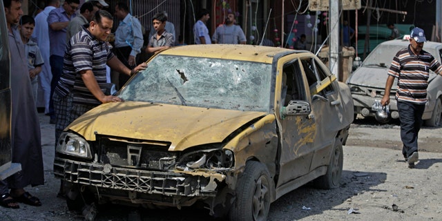 June 20: People inspect at the scene a car bomb attack in Baghdad, Iraq.