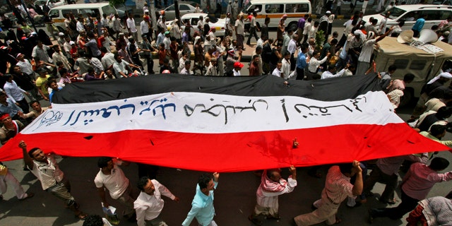 June 20: Anti-government protestors hold up their national flag during a demonstration demanding the resignation of Yemeni President Ali Abdullah Saleh, in Taiz, Yemen.