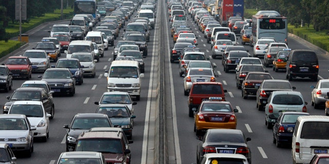 Vehicles wait during a traffic jam along a major thoroughfare in Beijing August 10, 2007. The Chinese capital will hold a test drill for keeping cars off the road during its 2008 Olympic Games, a crucial hurdle for the city beset by pollution and traffic jams, officials announced on Friday. Between Aug. 17 and 20, about 1.3 million of the city's 3 million vehicles will be ordered off the streets each day depending on whether licence plates end in an odd or even number. REUTERS/Claro Cortes IV (CHINA)
