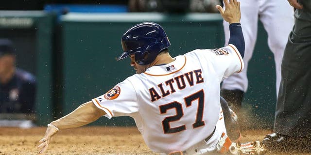 Jun 25, 2015; Houston, TX, USA; Houston Astros second baseman Jose Altuve (27) touches home plate as he scores a run during the fourth inning against the New York Yankees at Minute Maid Park. Mandatory Credit: Troy Taormina-USA TODAY Sports