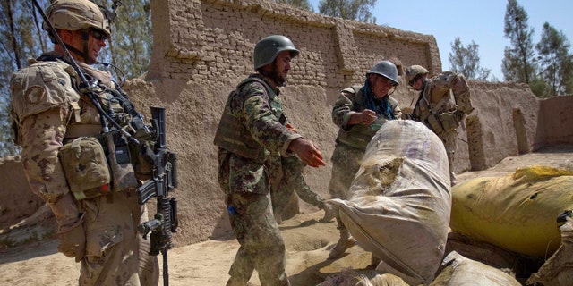 June 27: Afghan Army soldiers pile up approximately a thousand pounds of hashish to burn after it was discovered during a joint operation with Canadian Army's 1st Battalion 22nd Royal Regiment, in the Panjwaii district of Kandahar province, Afghanistan.