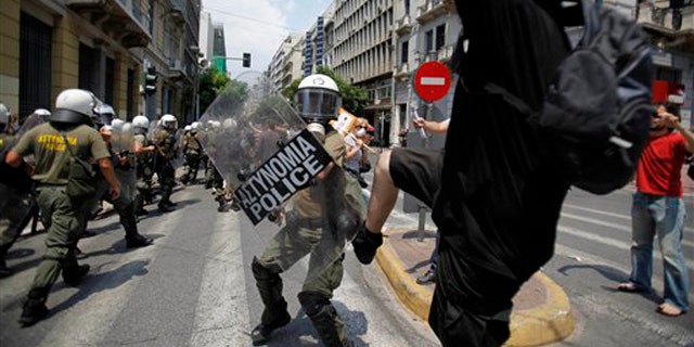 A demonstrator kicks a riot policeman during clashes in central Athens on Tuesday, June 29, 2010. Some 16,000 people took part in two separate demonstrations, the second of which turned violent as stone-throwing youths fought with riot police. Public services shut down across Greece Tuesday as workers walked off the job in a new nationwide general strike that disrupted public transport, left hospitals operating on emergency staff and pulled all news broadcasts off the air. (AP Photo)