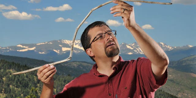 June 28: University of Colorado research associate Craig Lee holds a 10,000-year-old atlatl dart that had been frozen in an ice sheet near Yellowstone National Park. The dart was straight when it was entombed and became bowed from the melting and barely survived being snapped in half by a passing animal.