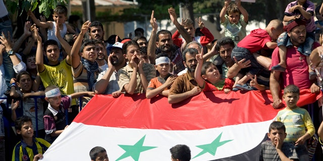 June 29: Syrian refugees demonstrate against their country's regime and its leader Bashar al-Assad in a camp in the Turkish border town of Yayladagi in Hatay province, Turkey.