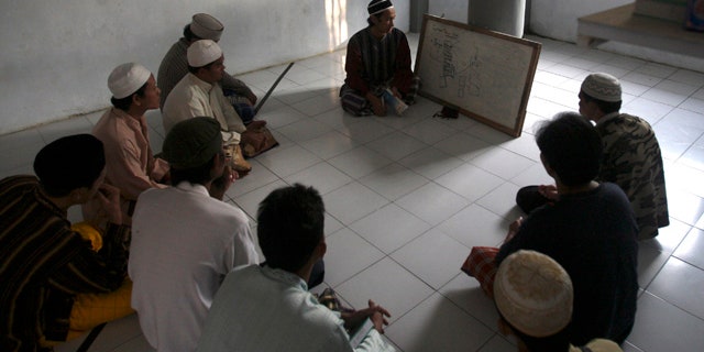 June 6: Prisoners attend a religious class led by a jailed militant Arif Syaifudin, also known as "Firdaus," in Block F of the Porong prison in East Java, Indonesia.