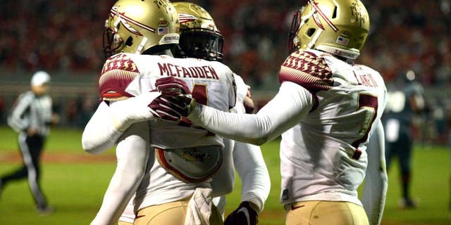 Nov 5, 2016; Raleigh, NC, USA; Florida State Seminoles defensive back Tarvarus McFadden (4) is congratulated by teammates after an interception during the first half against the North Carolina State Wolfpack at Carter Finley Stadium. Mandatory Credit: Rob Kinnan-USA TODAY Sports