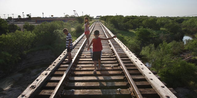 RIO GRANDE CITY, TX - AUGUST 05: Children walk across a railroad bridge August 5, 2008 in Rio Grande City, Starr County,Texas, along the border with Mexico. By many social indicators, Starr County is the poorest county in the United States. Few of its residents have full health or dental insurance and many of them must travel across the border to Mexico in order to get medical attention and buy medicine. The two-week Operation Lone Star, run by the Texas armed forces and state health officials, provided free medical care to more than 10,000 people in areas along the Texas-Mexico border. (Photo by John Moore/Getty Images)