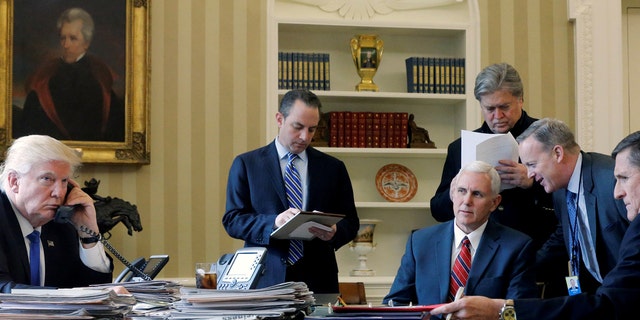 JANUARY 2017: US President Donald Trump (LR) along with Chief of Staff Reince Priebus, Vice President Mike Pence, Senior Advisor Steve Bannon, Director of Communications Sean Spicer and National Security Advisor Michael Flynn in the Oval Office in January 2017. 