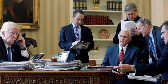 JANUARY 2017: U.S. President Donald Trump (L-R), joined by Chief of Staff Reince Priebus, Vice President Mike Pence, senior advisor Steve Bannon, Communications Director Sean Spicer and National Security Advisor Michael Flynn in the Oval Office in January 2017. 