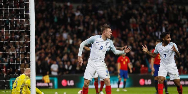 England's Jamie Vardy, center, celebrates with teammate Raheem Sterling, right, after scoring his side's second goal passing Spain's goalkeeper Jose Reina, left, during the international friendly soccer match between England and Spain at the Wembley stadium, London, Tuesday, Nov. 15, 2016. (AP Photo/Kirsty Wigglesworth)