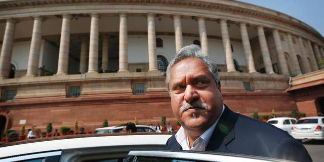 FILE- In this Feb. 27, 2013 file photo, Indian business tycoon and owner of Kingfisher Airlines Vijay Mallya gets into his car outside the Parliament in New Delhi, India. India will ask Britain to extradite Mallya to face charges of money laundering and bank demands that he pay back more than a billion dollars in loans extended to his now-defunct airline, the finance minister Arun Jaitley said Wednesday. (AP Photo/Saurabh Das, File)