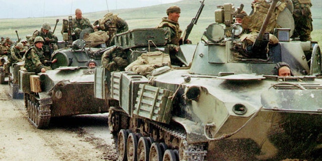 File: Russian paratroopers atop armored personnel carriers.