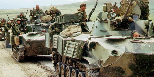File: Russian paratroopers atop armored personnel carriers.