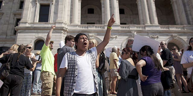 June 30: Richard Aviles of Northfield, Minn., leads the chanting of demonstrators opposed to a state shutdown on the steps of the state Capitol in St. Paul, Minn., (AP Photo/Star Tribune, Jeff Wheeler) .