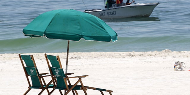 June 25: A boat skims for oil just off the beach in Pensacola Beach, Fla.