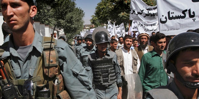 July 2: Afghan policemen escort protestors during an anti-Pakistan demonstration in Kabul, Afghanistan.